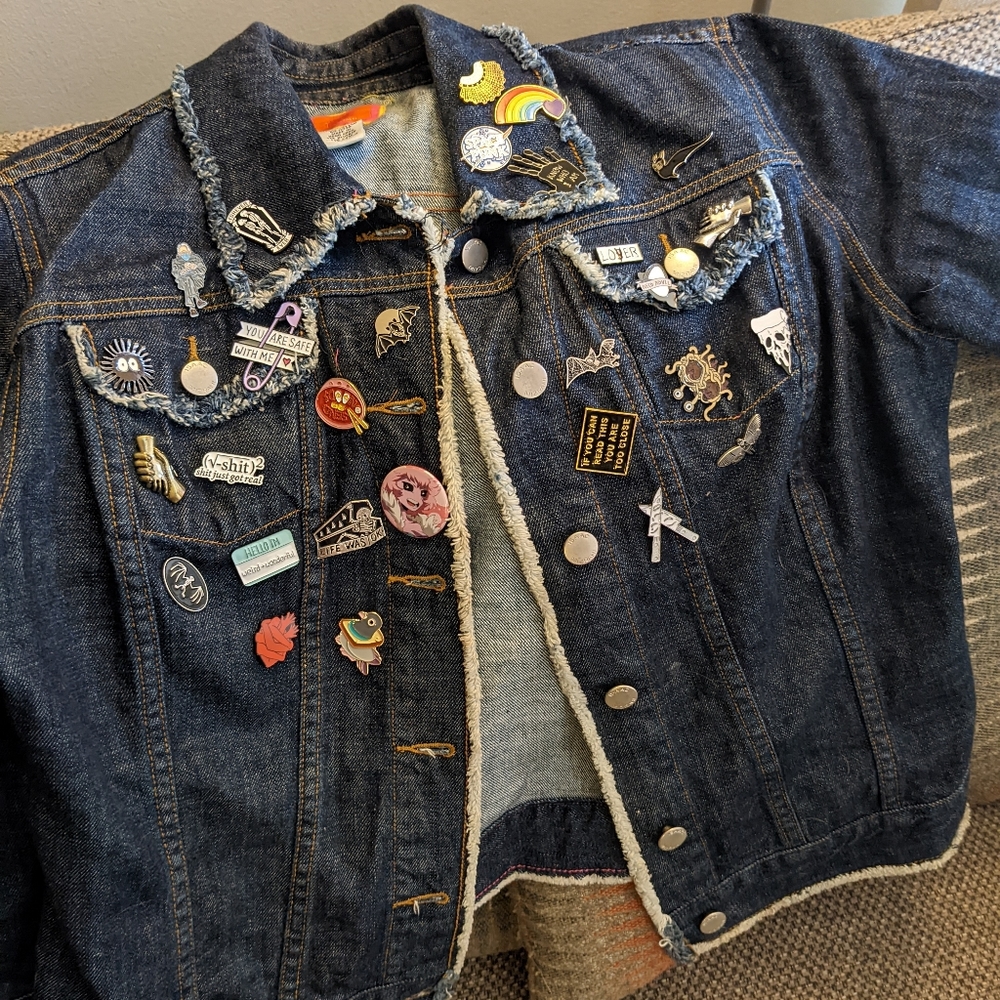 Frayed edge dark denim jacket loaded with enamel pins